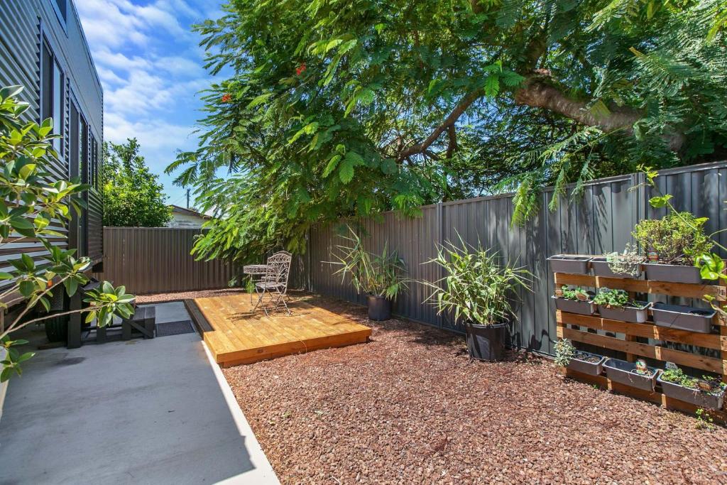 un jardín con un banco y una valla con plantas en Faraway Retreat, en Urangan