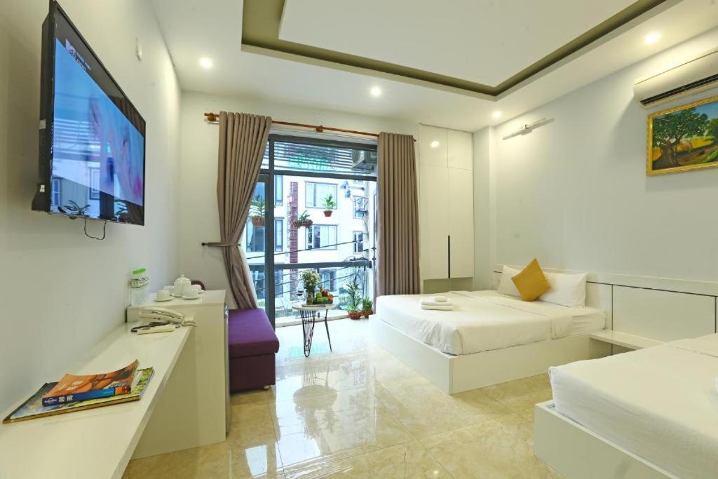 Habitación de hotel con cama, TV y sofá en Lis Hotel en Da Nang