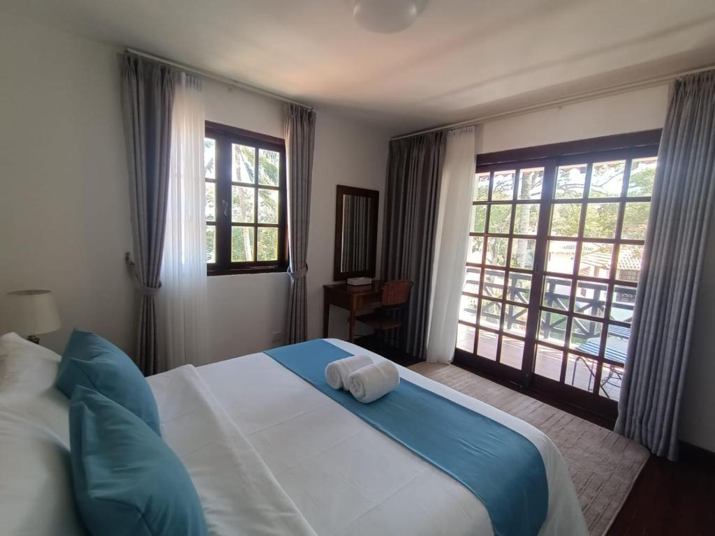 a bedroom with a bed and two windows at Sea View Villa @ Nongsa Resort in Telukmataikan