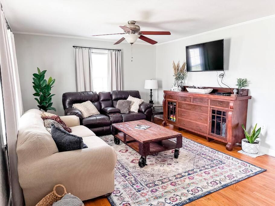 a living room with a couch and a table at The Grate House - Fire Table - Grill - Fenced Yard in Searcy