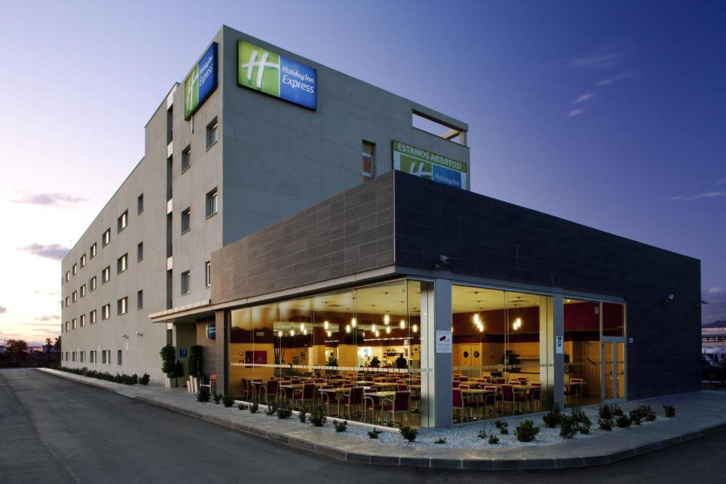 een groot gebouw met tafels en stoelen erin bij Holiday Inn Express Málaga Airport, an IHG Hotel in Málaga
