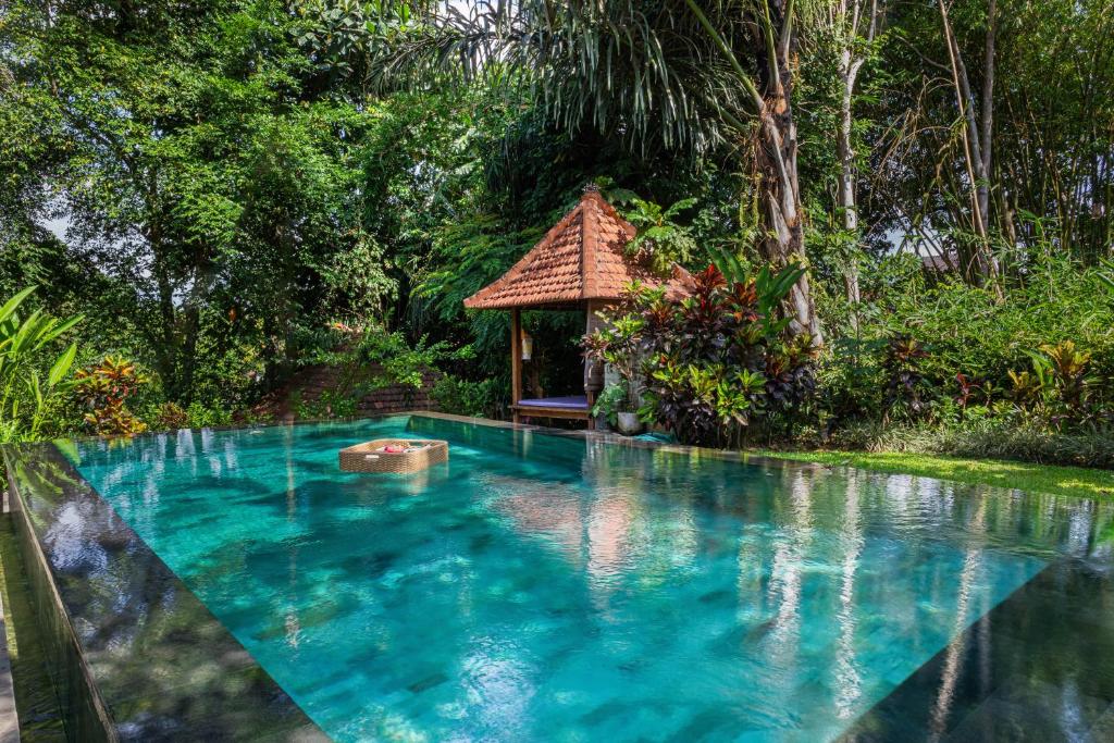 a swimming pool in front of a gazebo at Sari Bamboo Villas in Ubud