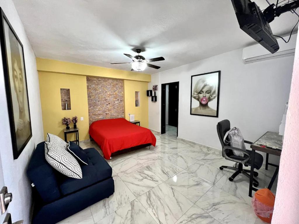- une chambre avec un lit rouge et un canapé dans l'établissement Cuarto C con cochera cerca del hospital general, à Ciudad Victoria