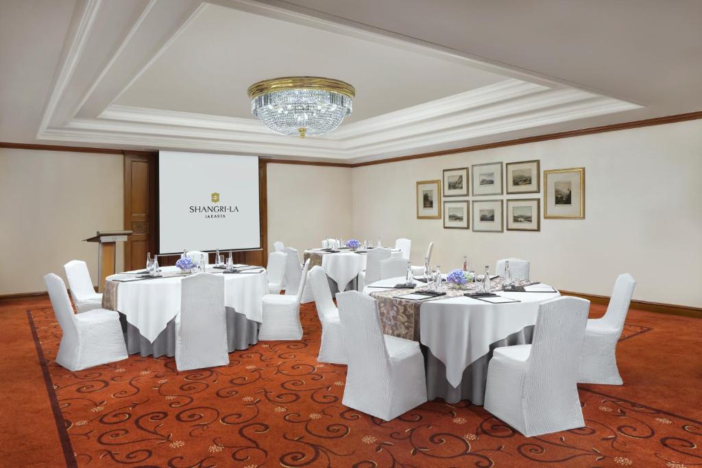 a conference room with white tables and white chairs at Shangri-La Jakarta in Jakarta