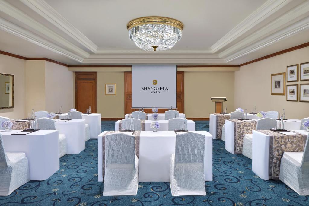 a conference room with white tables and chairs at Shangri-La Jakarta in Jakarta