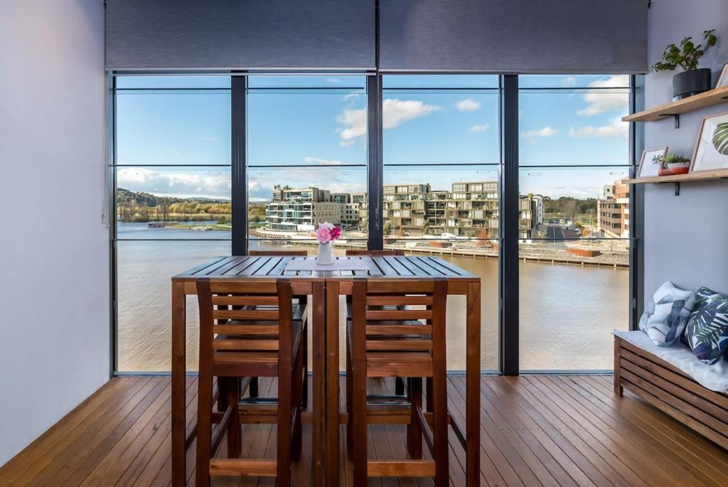 uma mesa de jantar com cadeiras e uma grande janela em Stunning 1BR Apartment with Water Views em Kingston 