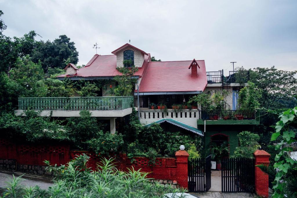 una casa con techo rojo y valla en Gorayya Villa, en Dehradun