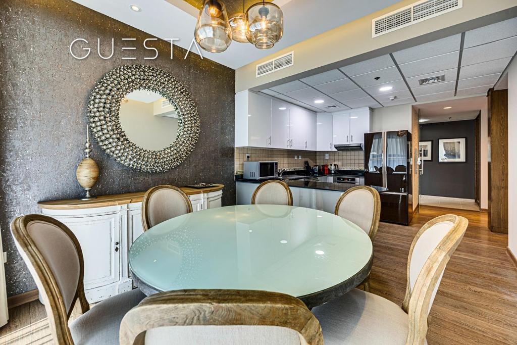 a dining room with a glass table and a kitchen at Elite Residence, Dubai Marina in Dubai