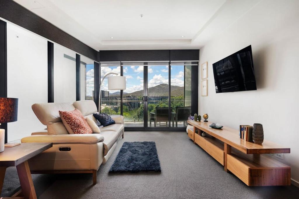 sala de estar con sofá y TV en Sky High Views in the Heart of Canberra, en Canberra