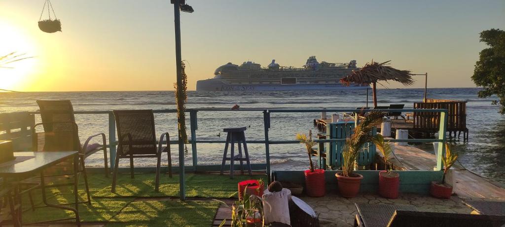 a cruise ship is in the water with a balcony at Victoria s Beach House and Snorkeling Center in Roatan