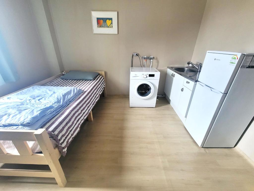 een kleine kamer met een bed en een wasmachine bij Wandonesia in Wando