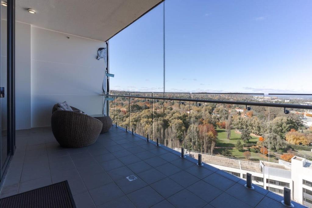 a room with a balcony with a view of trees at 1-Bed with Amazing Views, Pool, Gym, BBQ & Parking in Canberra