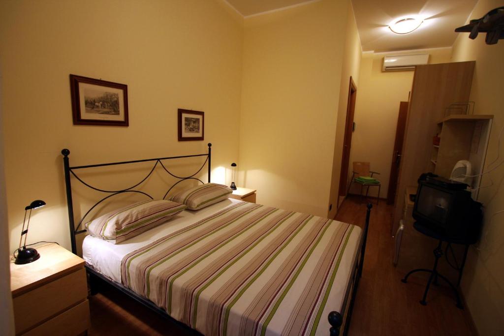 1 dormitorio con 1 cama y TV en Bed and Breakfast Centrostorico, en Sarnico