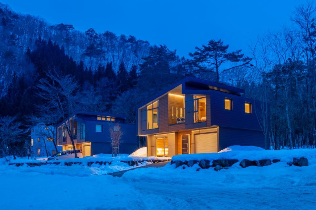 ein Haus im Schnee in der Nacht in der Unterkunft Eminence by The Hakuba Collection in Hakuba