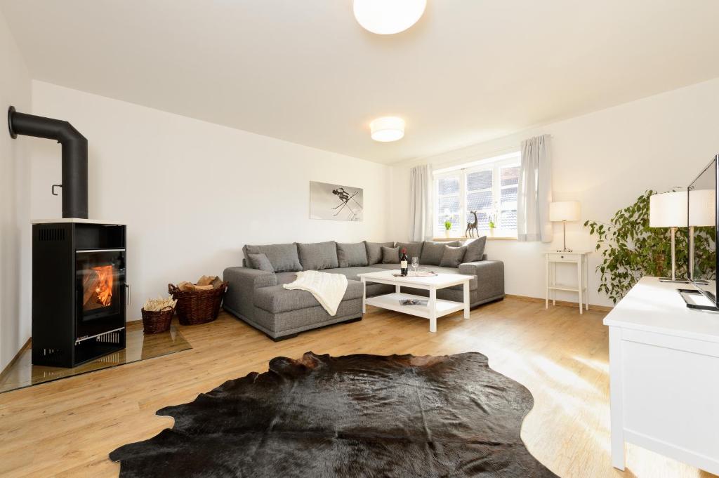uma sala de estar com um sofá e uma lareira em "Viktoria Apartments" - Annehmlichkeiten von 4-Sterne Familien-und Wellnesshotel Viktoria können mitgenutzt werden em Oberstdorf