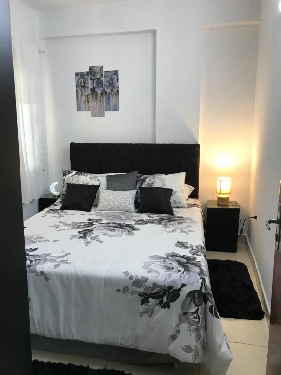 a bedroom with a bed with a black and white comforter at CALENA I in San Lorenzo