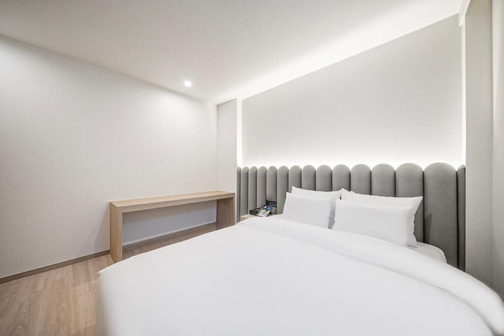 Postel nebo postele na pokoji v ubytování Gyeongju Poverta Hotel