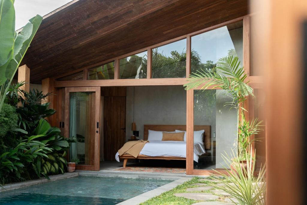 a bedroom in a house with a bed and a pool at Masa Kini NEW 3 BR Family Villa with Pool walking distance to Uluwatu Beach in Uluwatu