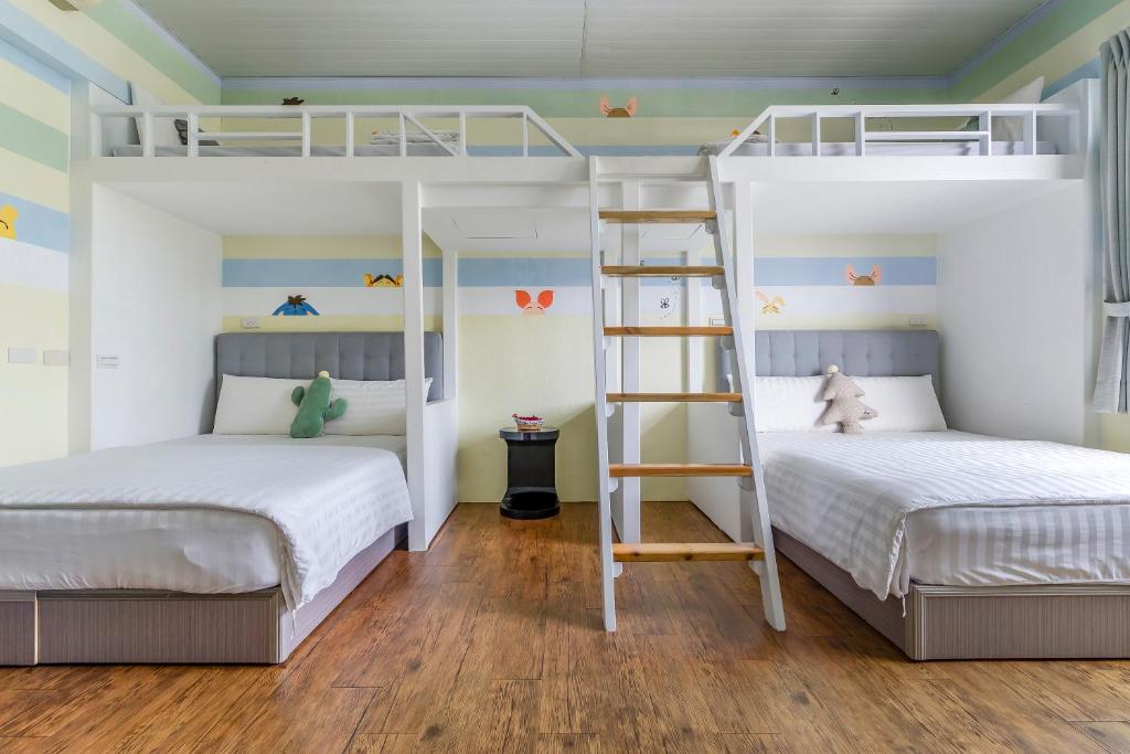 two beds in a room with two bunk beds at Bo Ya Homestay in Xiaoliuqiu
