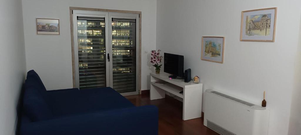 a living room with a blue chair and a television at Global Guest PN in Lisbon