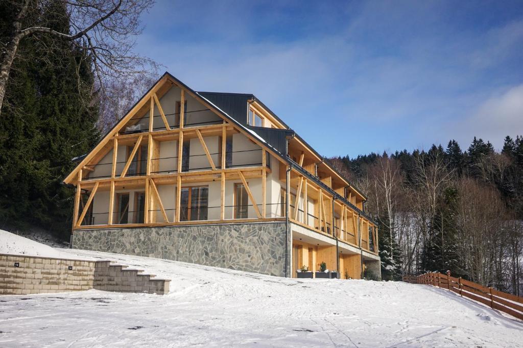 ein großes Holzhaus im Schnee in der Unterkunft Apartman Beranek Sumava in Železná Ruda