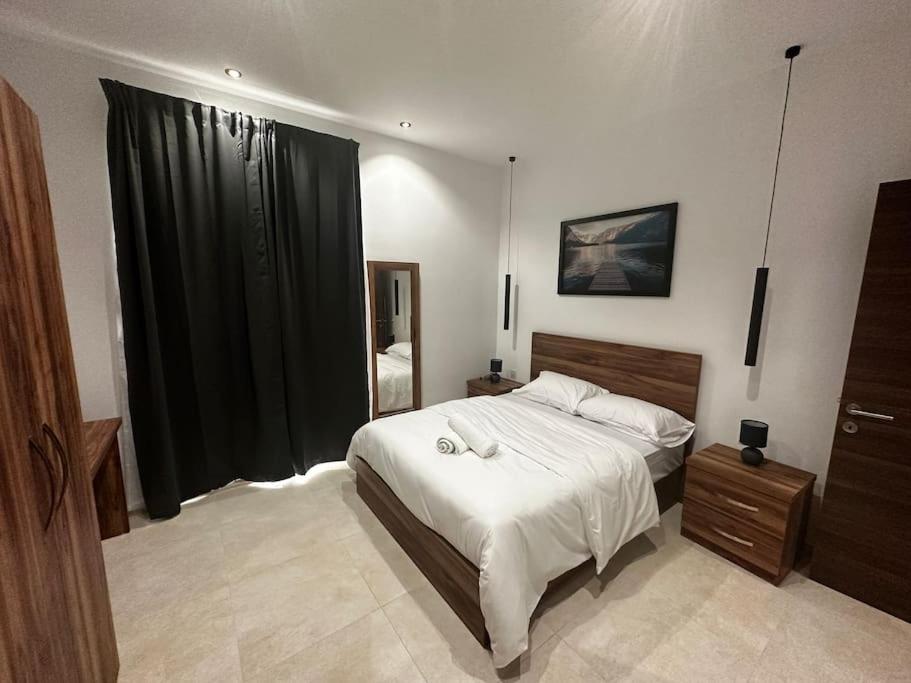 1 dormitorio con cama y ventana grande en Smart 1 Bedroom Apartment in Noah Apartments, Gzira, en Il-Gżira