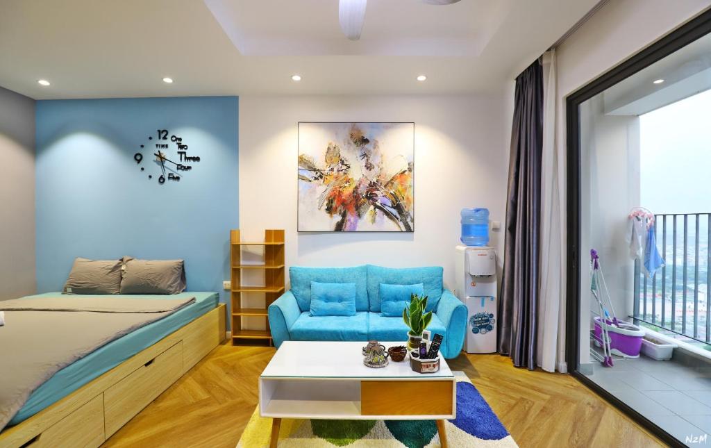 una camera con letto e sedia blu di Harmony Vinhomes D'Capitale a Hanoi