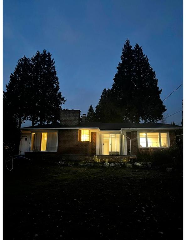 a house with its lights on in the dark at Home in West Vancouver in West Vancouver