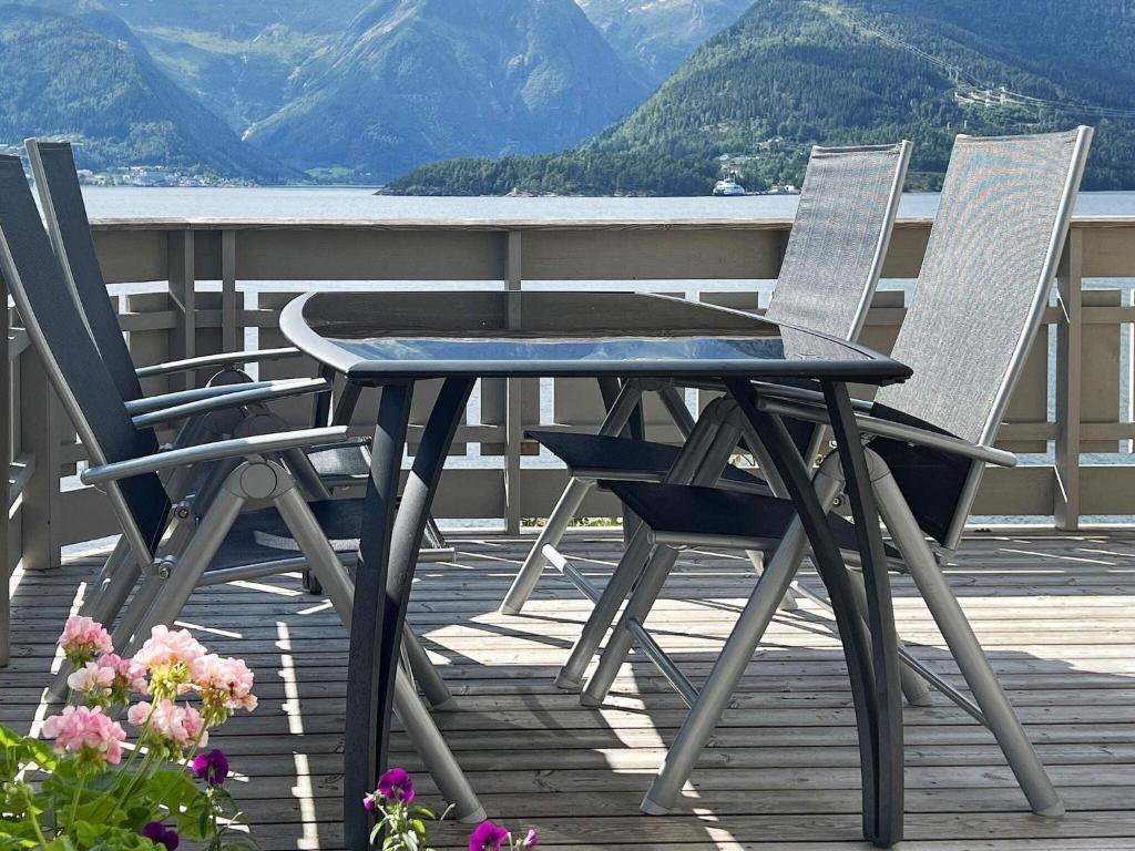 Holiday home leikanger في ايكنجر: كرسيين وطاولة على سطح مع جبال