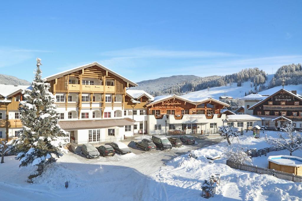 a lodge in the snow with cars parked at Aparthotel Paradies in Flachau