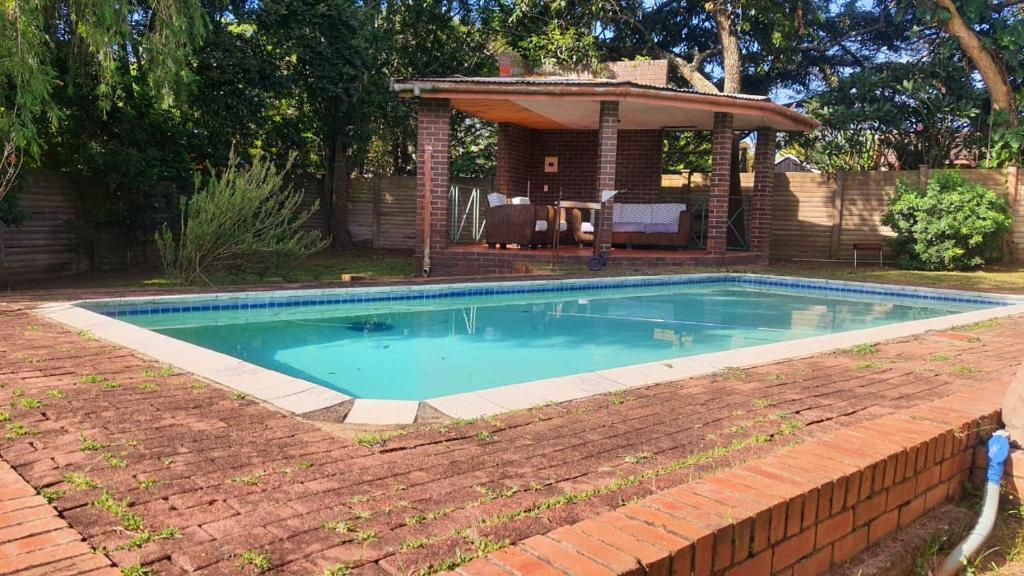 a swimming pool in a yard next to a house at Secret guest house in Pietermaritzburg
