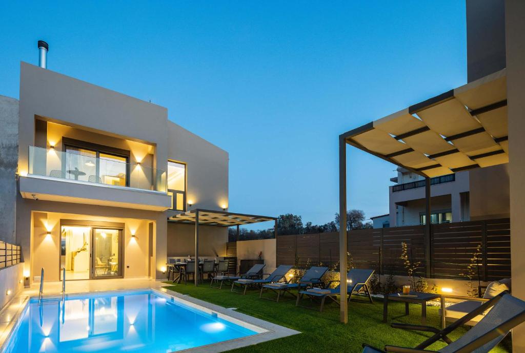 a swimming pool in the backyard of a house at New Modern Villas with Private Pools and Walking distance to Beach in Panormos Rethymno