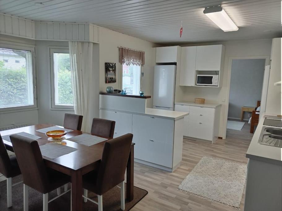 cocina y comedor con mesa y sillas en Talo 140 m2, en Siilinjärvi
