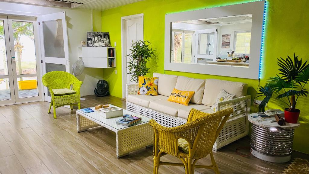 ein Wohnzimmer mit einem Sofa, einem Tisch und Stühlen in der Unterkunft ShineAwayHomes - Family Beach Front No air con in Rarotonga