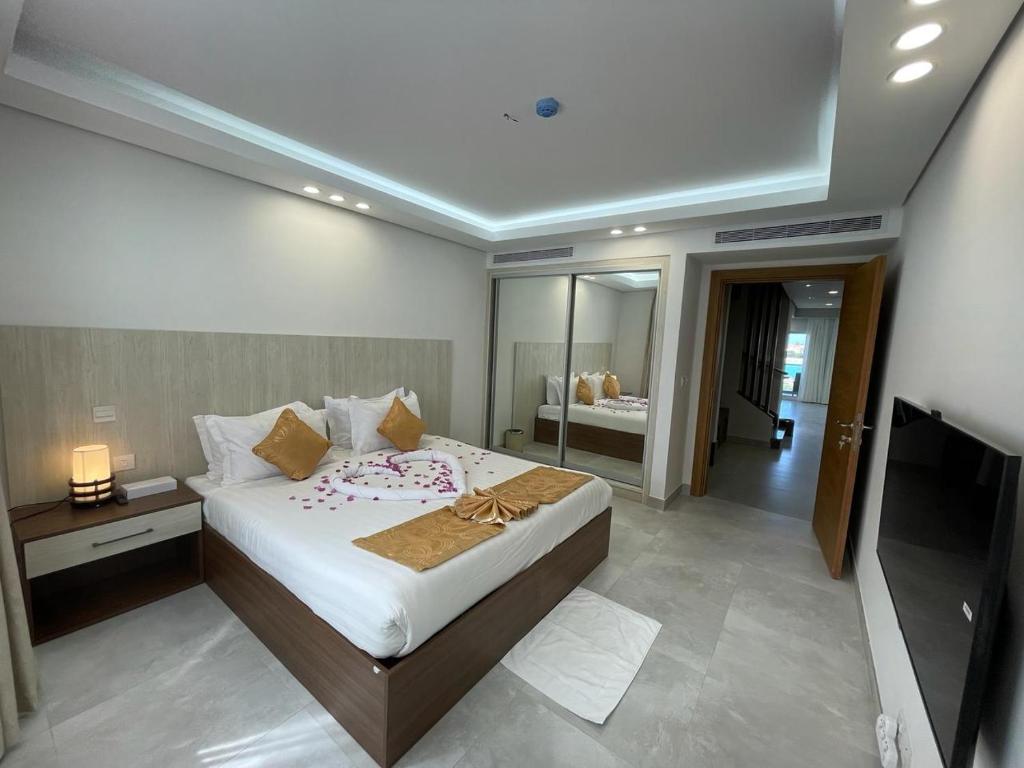 a bedroom with a large bed and a television at فلل الغروب in Durat  Alarous