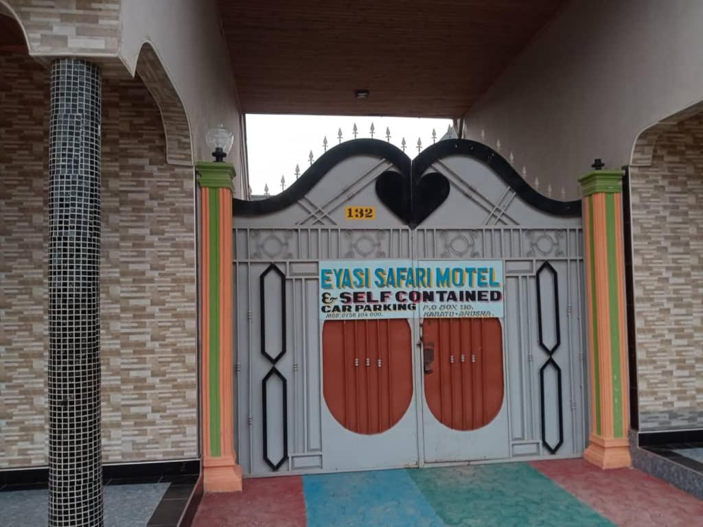Una puerta en un edificio con un cartel. en Eyasi Safari Motel, en Mangola