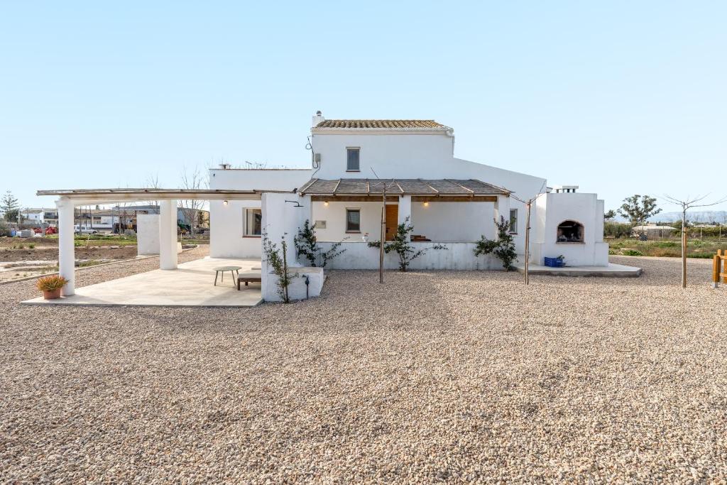 una casa bianca con un cimitero davanti di Mas Midó a Sant Jaume d'Enveja
