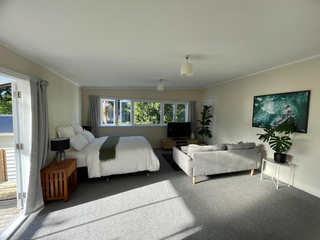 een slaapkamer met een bed en een bank bij Urban Kingsland Studio in Auckland