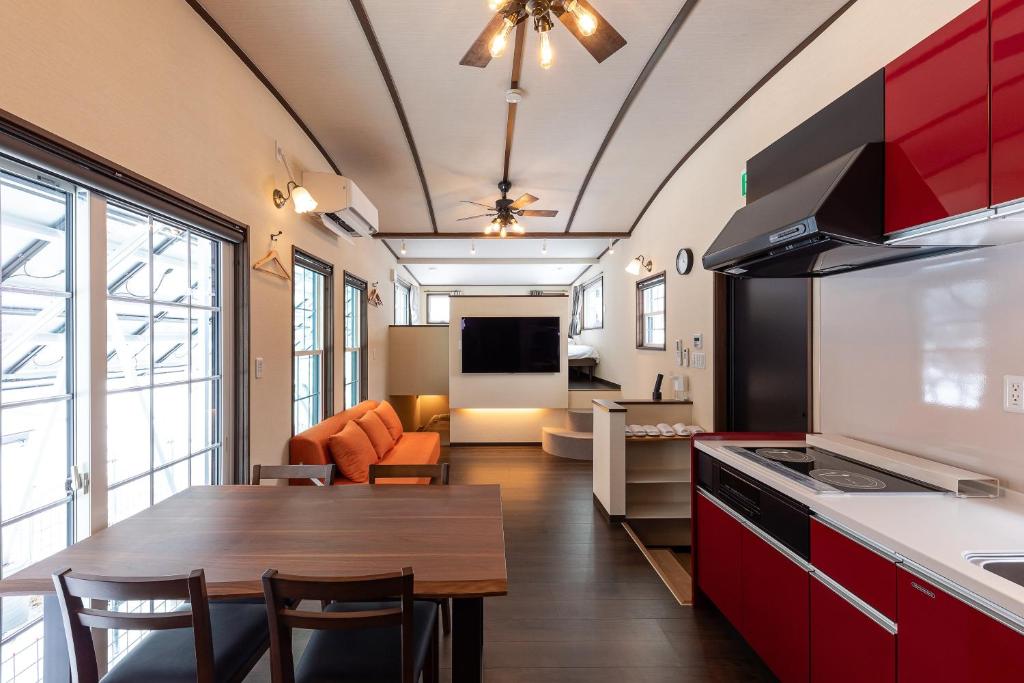 a kitchen and living room with a table and a couch at Furano Trailer Village Den in Furano