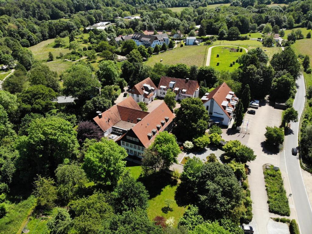 an aerial view of a house with trees and a road at Hotel Lindenhof in Bielefeld