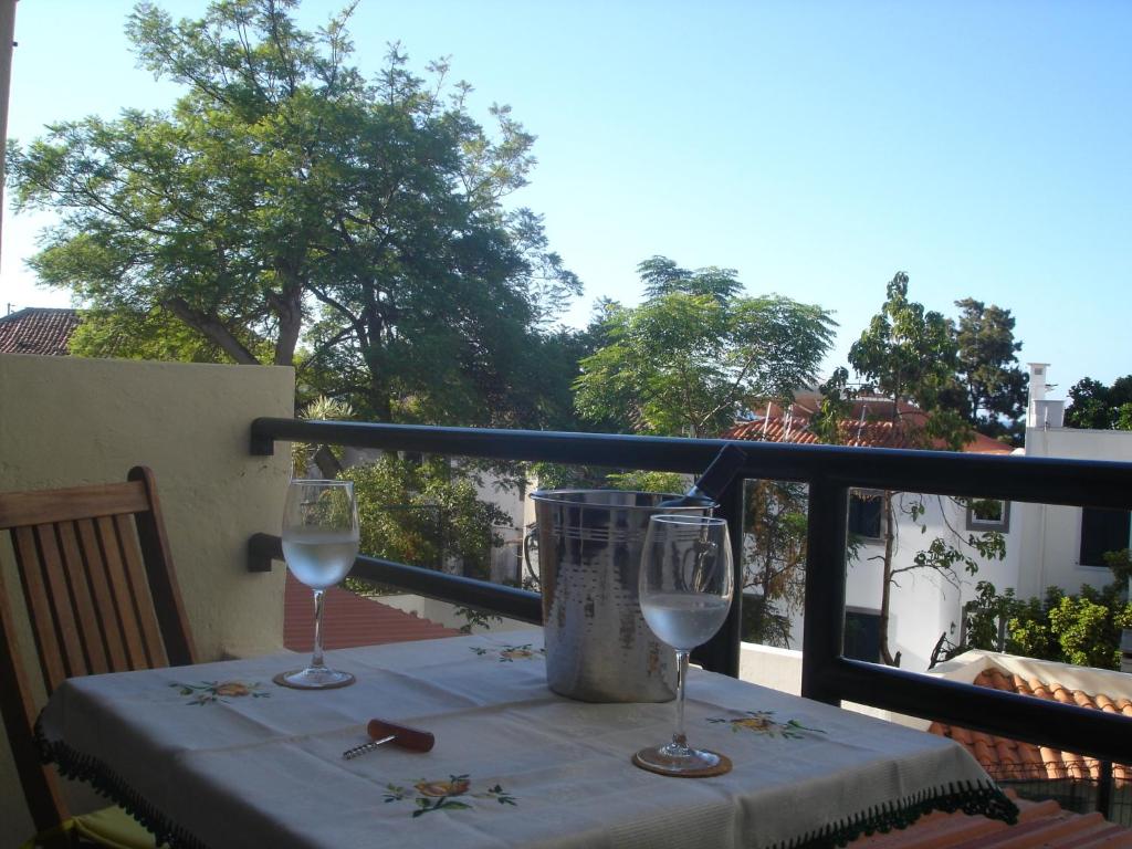 una mesa con 2 copas de vino en el balcón en Shearwaternest Apartment AL, en Funchal