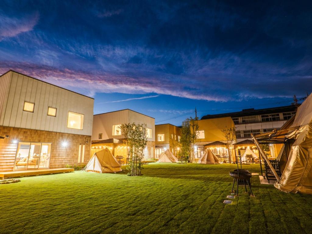 un grupo de edificios con tiendas en un patio por la noche en AMAZING LIFESTYLE GLAMPING HOTEL - Vacation STAY 43987v en Nagahama
