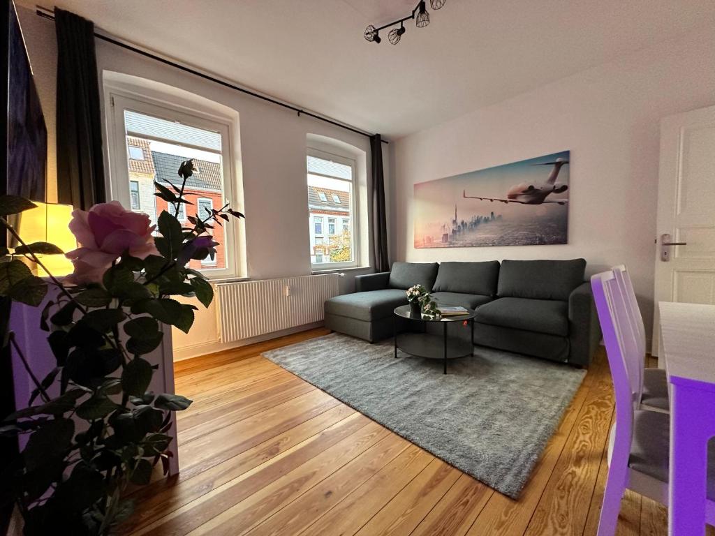 a living room with a couch and two windows at TOP Altbauwohnung in Kiel Mitte in Kiel