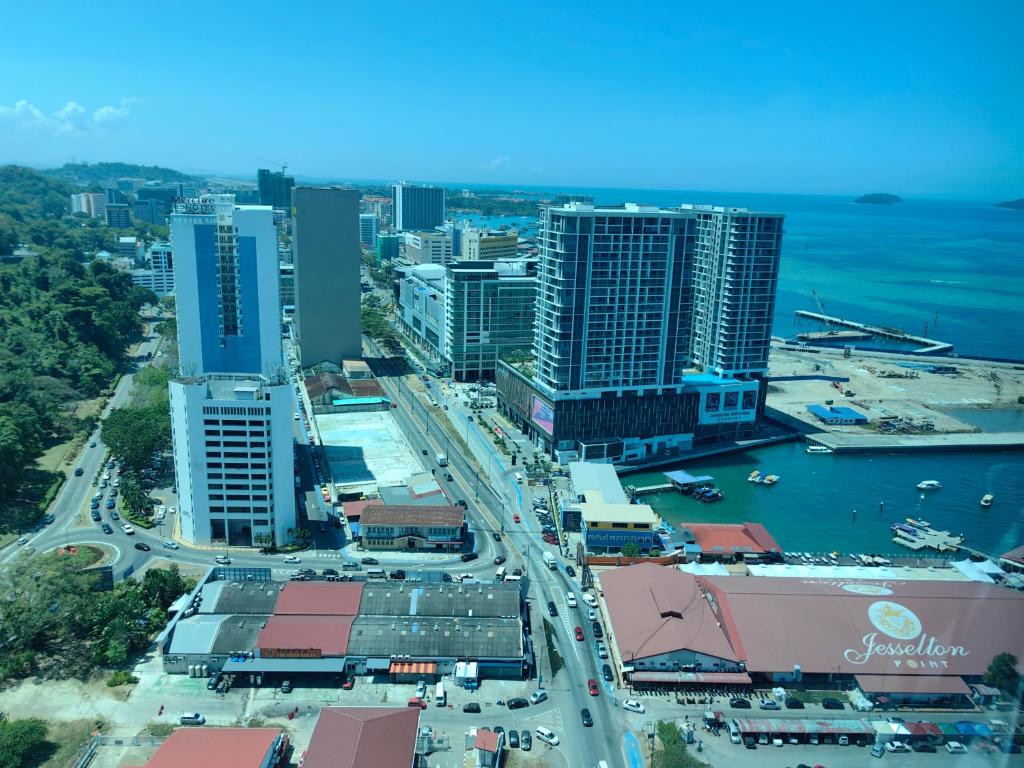 Jesselton Quay by Miraton Lodge 2 في كوتا كينابالو: اطلالة جوية على مدينة بها مباني والمحيط