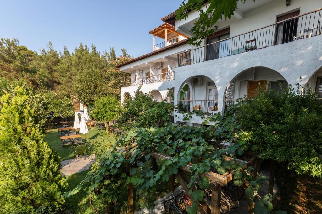 un bâtiment avec un jardin en face dans l'établissement Liotopi, à Olympiada