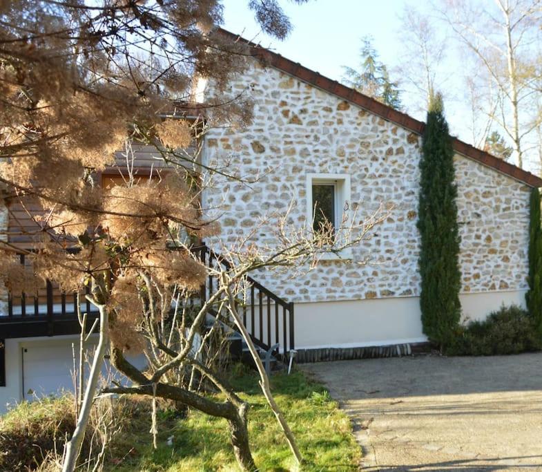 - un bâtiment en pierre avec une fenêtre et un arbre dans l'établissement studio lumineux au calme, à Gif-sur-Yvette