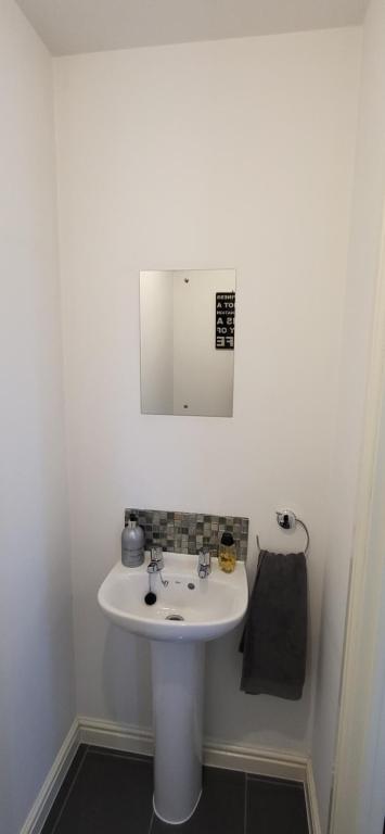 ein Badezimmer mit einem weißen Waschbecken und einem Spiegel in der Unterkunft Hatley Residencies in Dudley