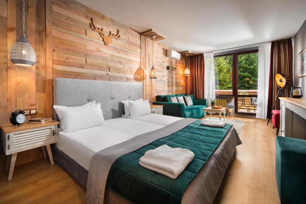 a bedroom with a large bed and a living room at Room in BB - Hotel Moura Deluxe Room n5187 in Borovets