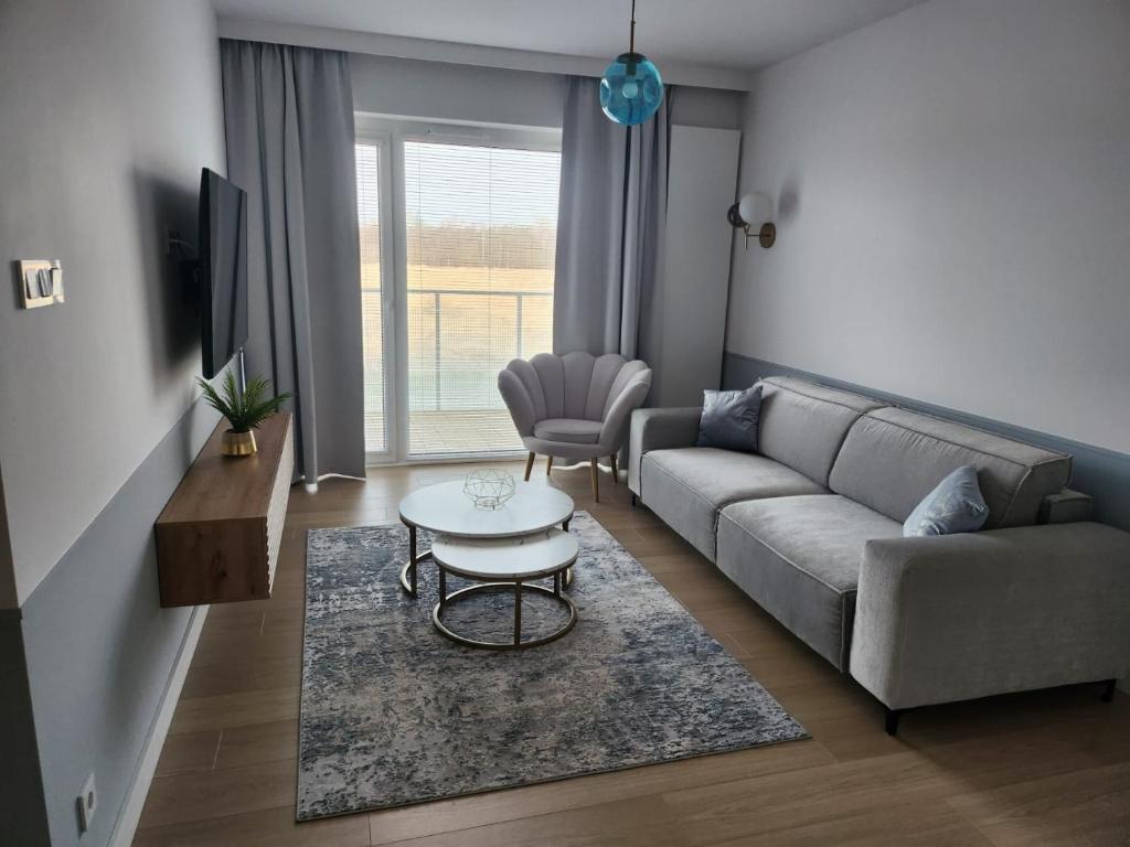 uma sala de estar com um sofá e uma mesa em Apartament Kołobrzeg Aqua Polanki em Kolobrzeg