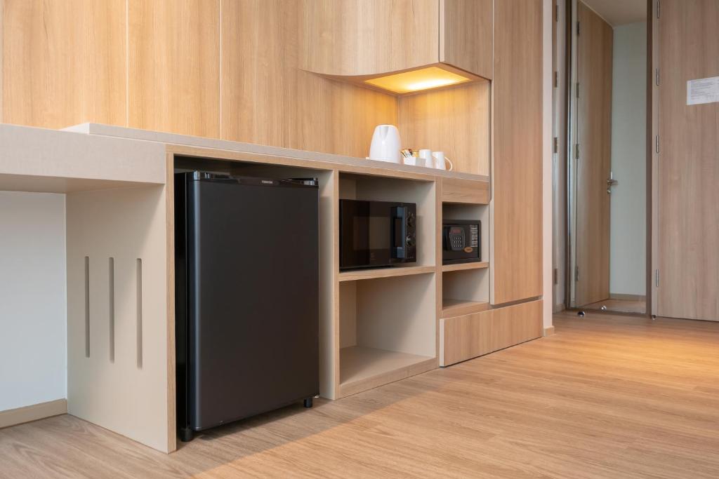 A compact in-room kitchenette and storage wall with a mini-fridge and microwave.
